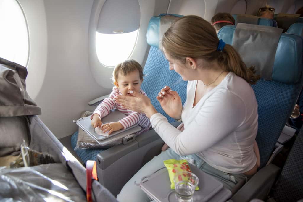 toddler flying and eating on airplane